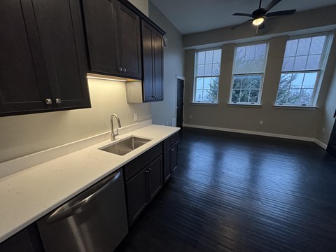 A kitchen with dark wood cabinets and a white countertop.