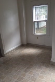 A room with a window and tiled flooring.