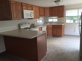 A kitchen with brown cabinets and a white counter top.