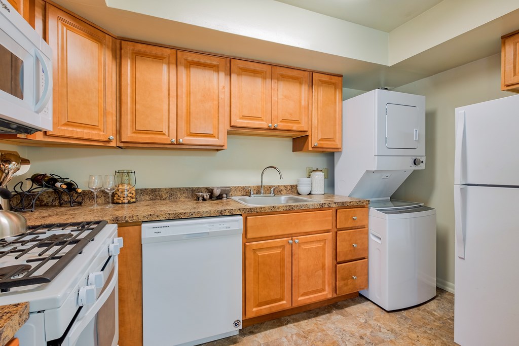 A kitchen with wooden cabinets and white appliances.