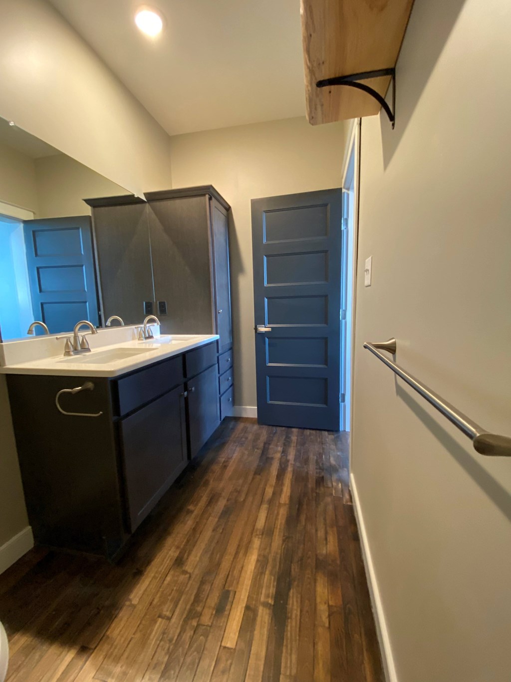 A kitchen with dark wood floors and a white sink.