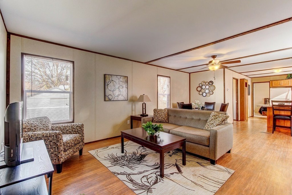 A living room with a brown couch, a coffee table, and a television.