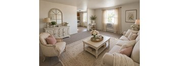 A living room with a white sofa, armchair, and coffee table.