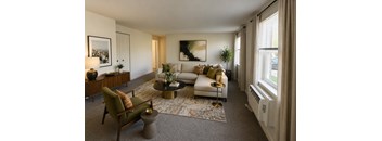 A living room with a white couch, a green chair, and a coffee table.