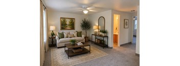 A living room with a white couch, a coffee table, and a painting on the wall.