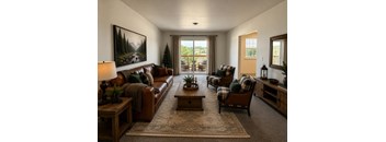 A living room with a brown couch, two chairs, and a coffee table.