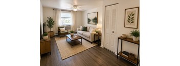 A living room with a white couch, a brown coffee table, and a painting on the wall.