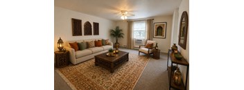 A living room with a white couch, a brown coffee table, and a rug with a pattern.