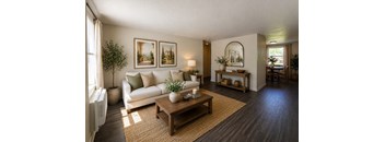 A living room with a white couch, a coffee table, and a painting on the wall.