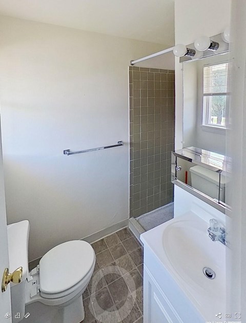 A white toilet with a white sink and a white bathtub in a bathroom.