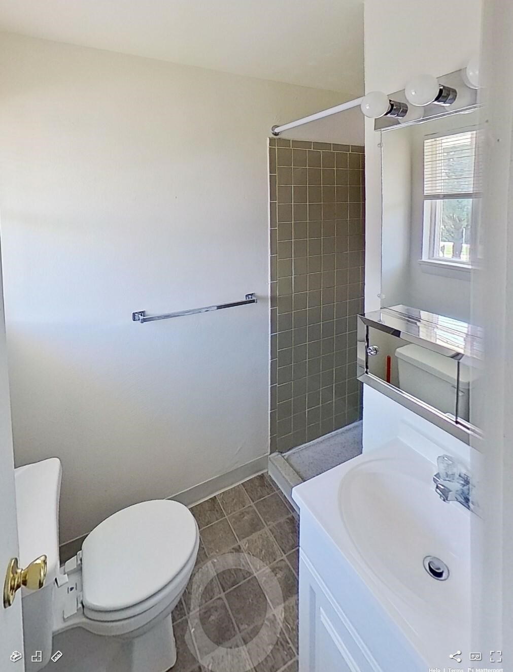 A white toilet with a white sink and a white bathtub in a bathroom.