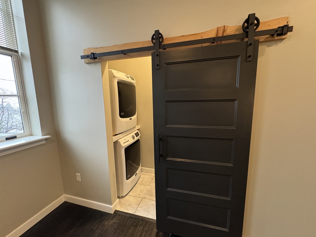 A black door with a sliding barn door hardware is installed in a room.
