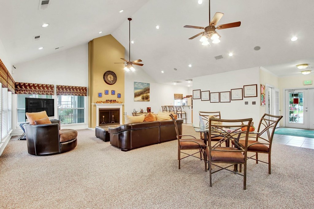 A living room with a fireplace and a ceiling fan.