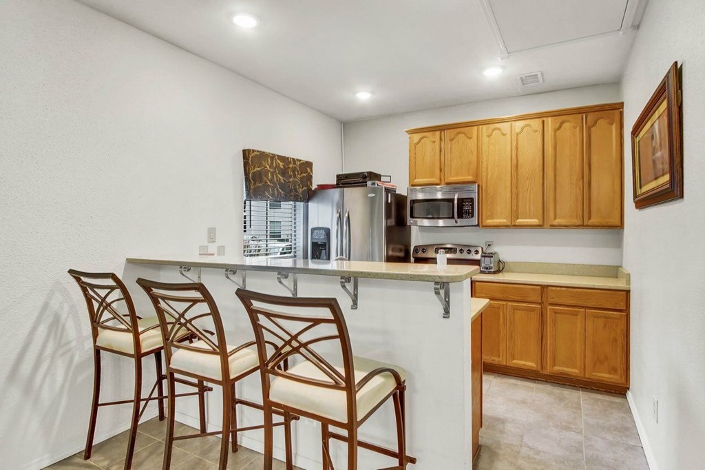 A kitchen with wooden cabinets and a white countertop.