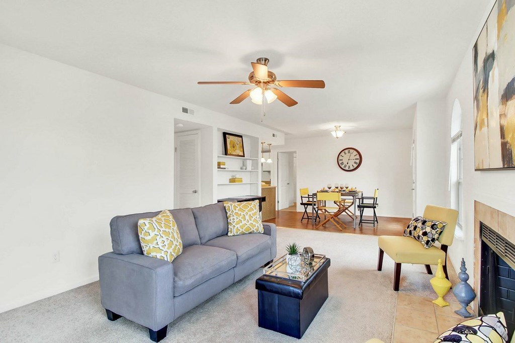 A living room with a grey couch and a yellow pillow.