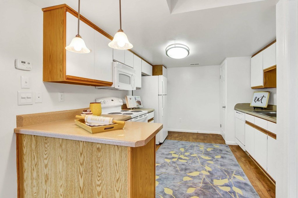 A kitchen with wooden cabinets and a white refrigerator.