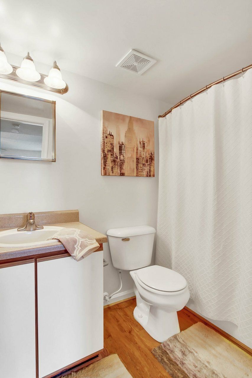 A white toilet sits next to a sink in a small bathroom.
