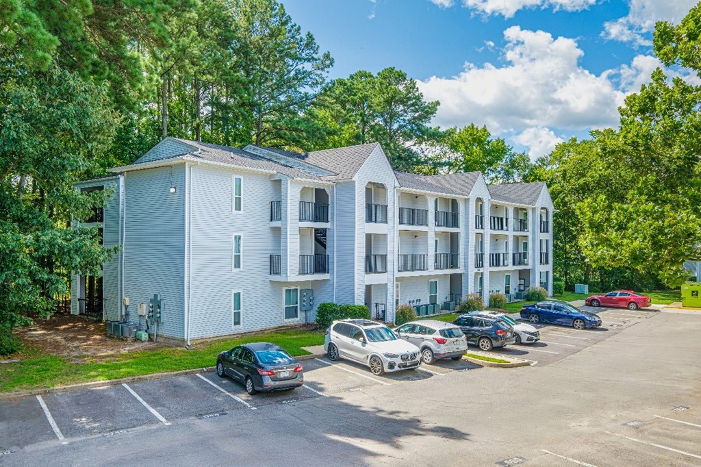 A parking lot with cars and a building in the background.