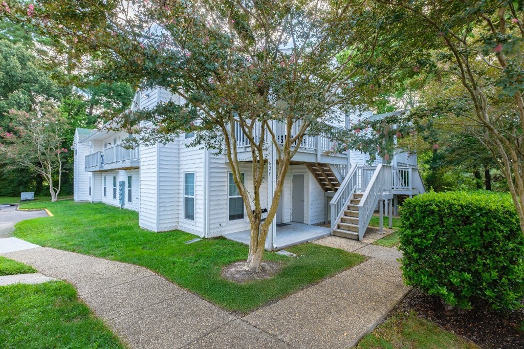 A white house with a tree in front of it.