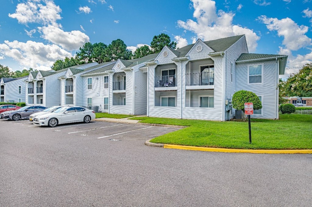 A white building with a parking lot in front of it.