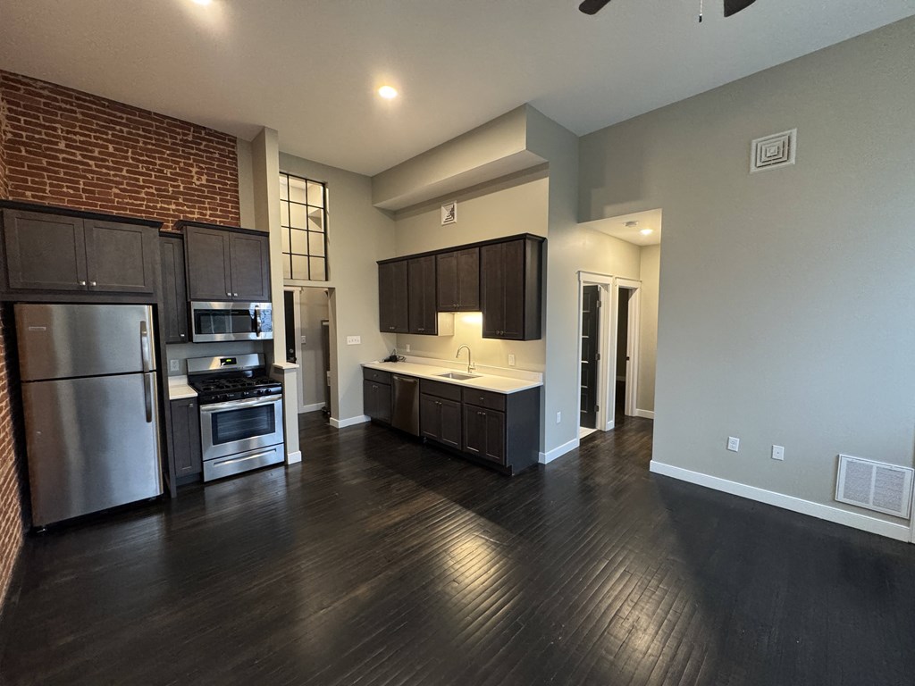 A kitchen with a refrigerator, oven, and microwave.
