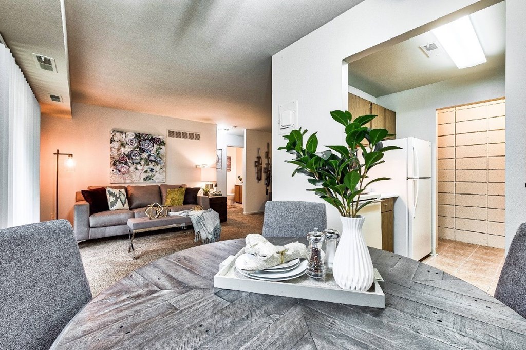 A modern dining room with a grey table and chairs.