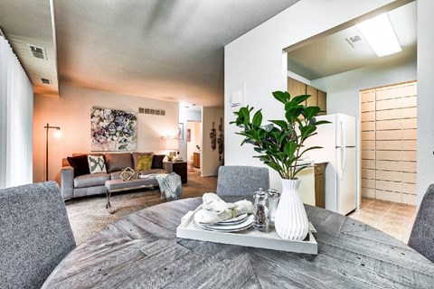 A modern dining room with a grey table and chairs.