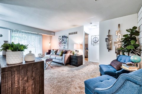 A living room with a blue chair and a white couch.