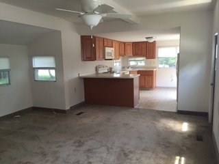 A kitchen with a fan on the ceiling and a countertop with a sink.