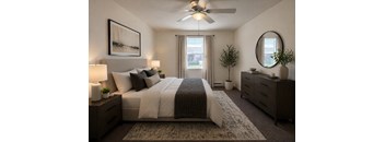 A bedroom with a large bed, a ceiling fan, and a window with curtains.