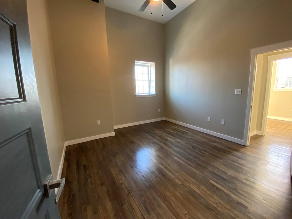 A room with wooden floors and a ceiling fan.