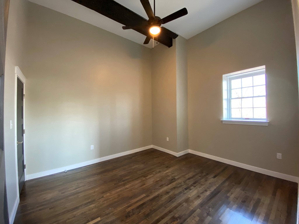 A room with a ceiling fan and a window.