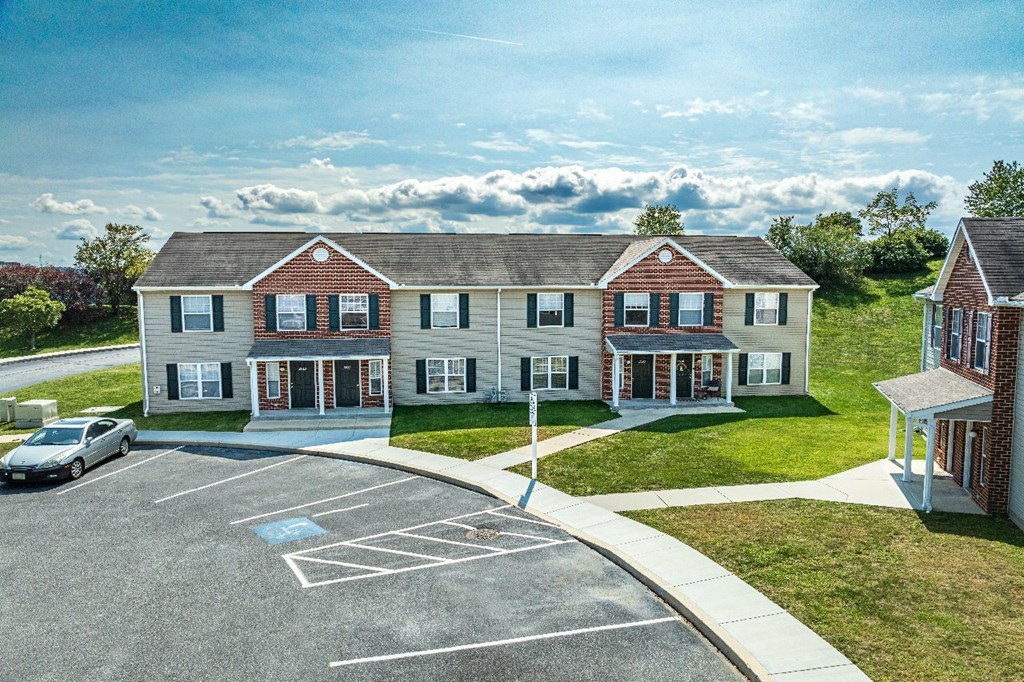A car is parked in a parking lot in front of a building.