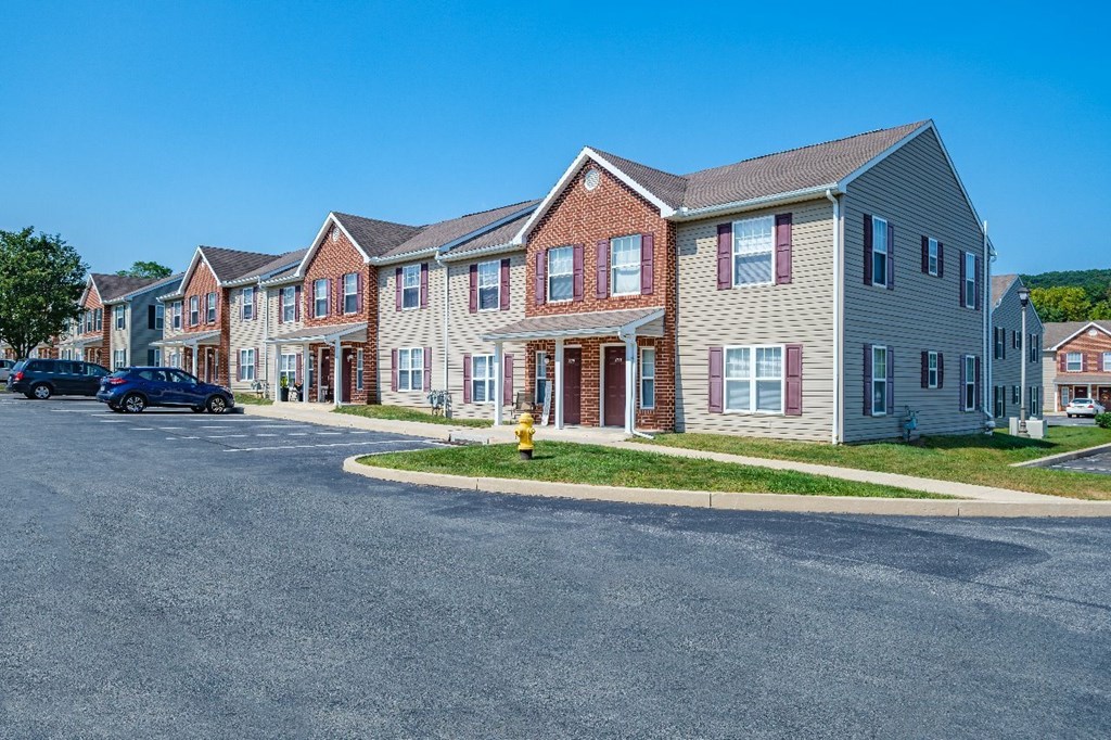 A row of houses with a car parked in front of them.