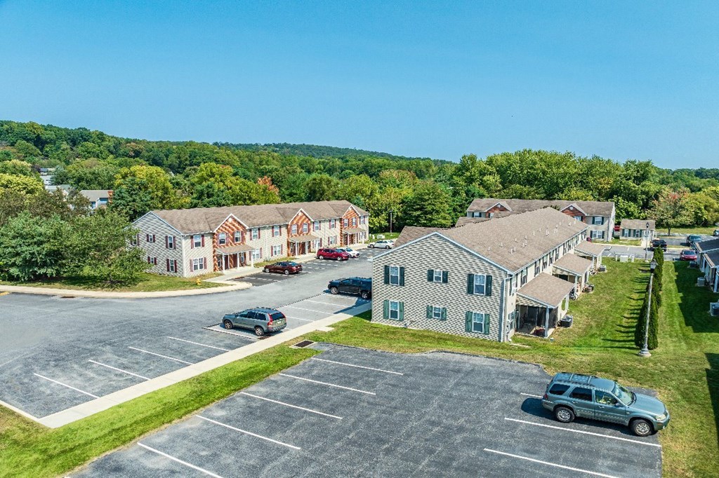 A parking lot with cars and a building in the background.