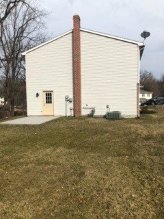 A small white building with a red brick chimney.