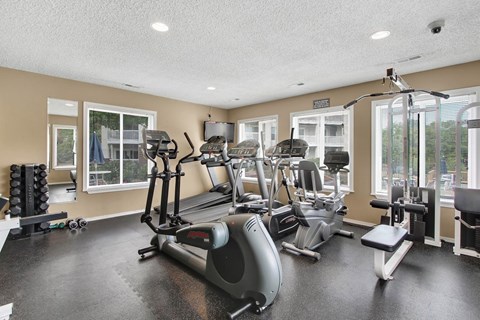 A spacious gym with a variety of equipment including treadmills, stationary bikes, and weight machines.
