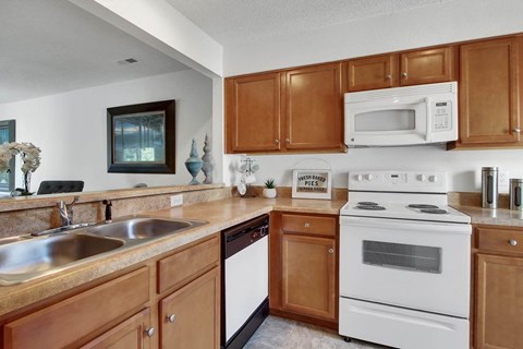 A kitchen with wooden cabinets and a white stove.