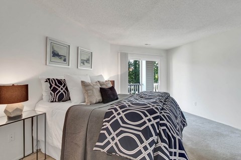 A bedroom with a large bed and two pictures on the wall.