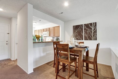 A dining room with a table and chairs.