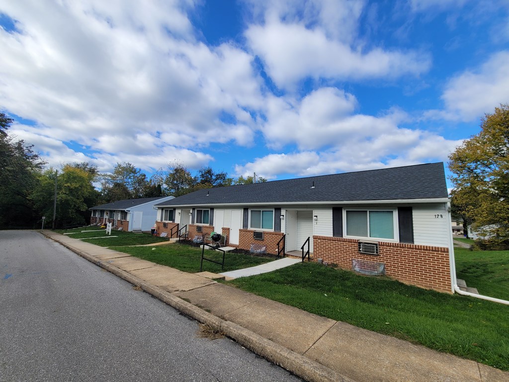A row of houses with a blue sky and clouds above.