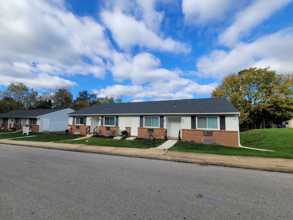 A row of houses with a blue sky and clouds above.