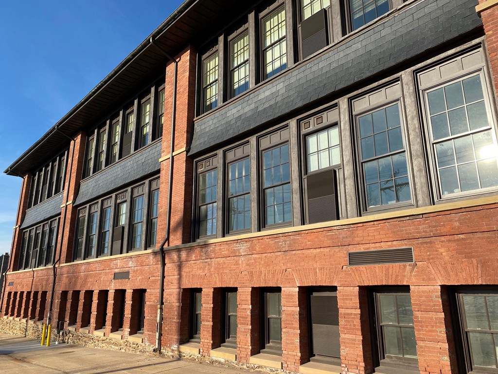 A red brick building with a black roof and white trim.