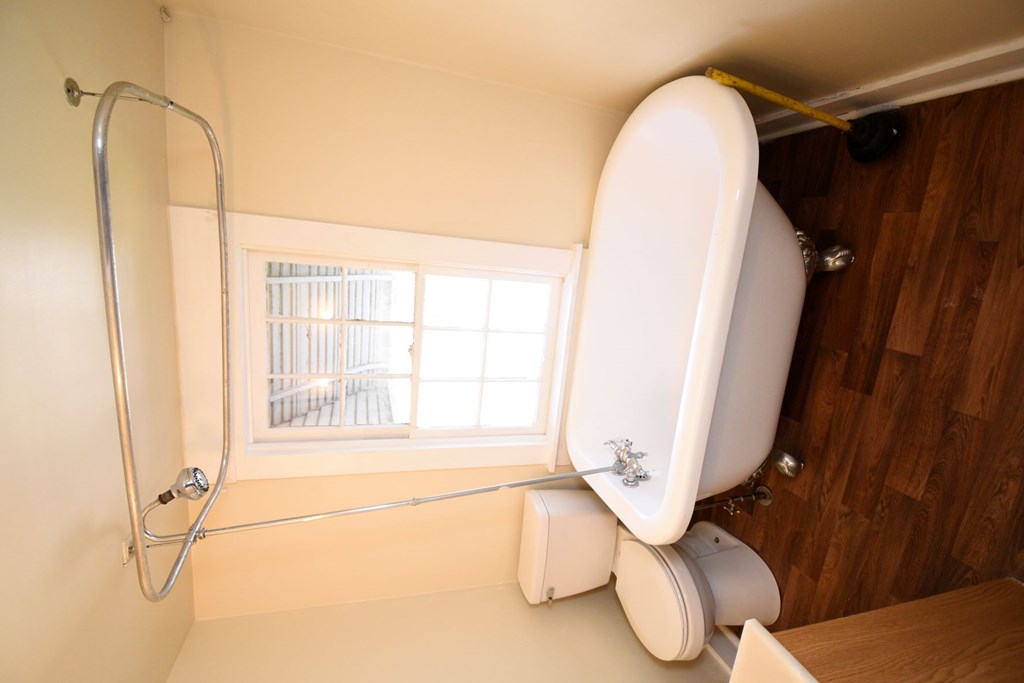 A white toilet with a white bidet and a shower head in a bathroom.