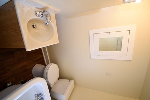 A bathroom with a toilet, sink, and mirror.