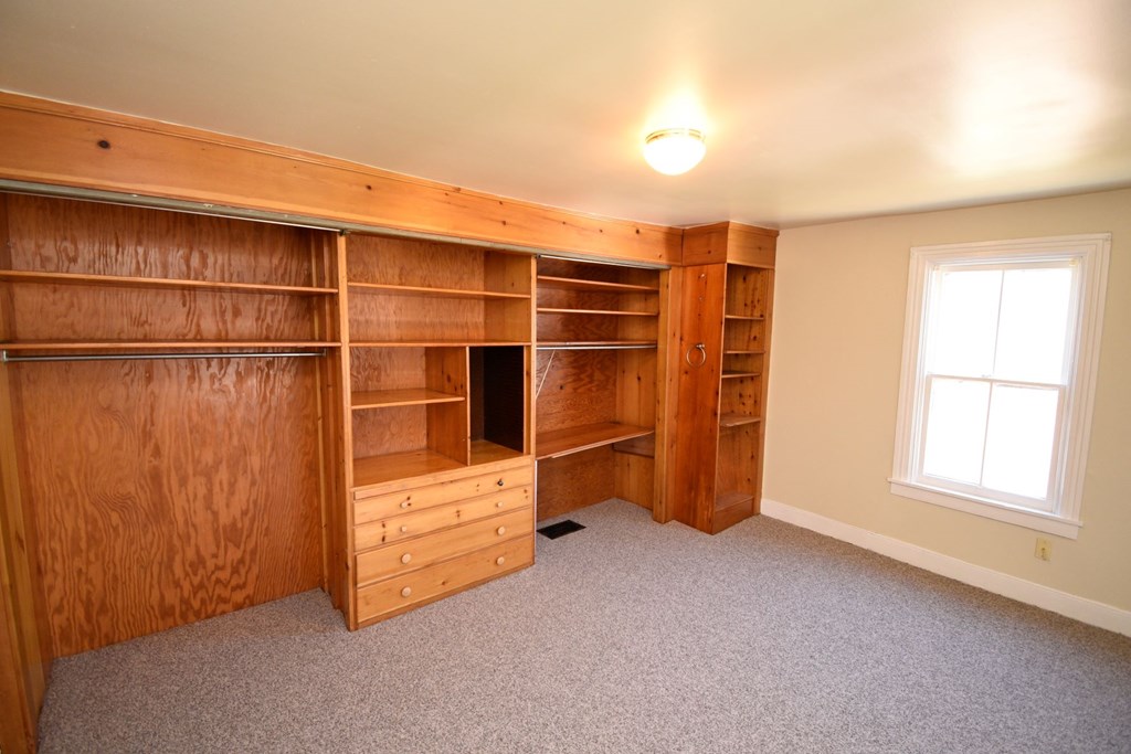 A room with a large built-in bookcase and a window.