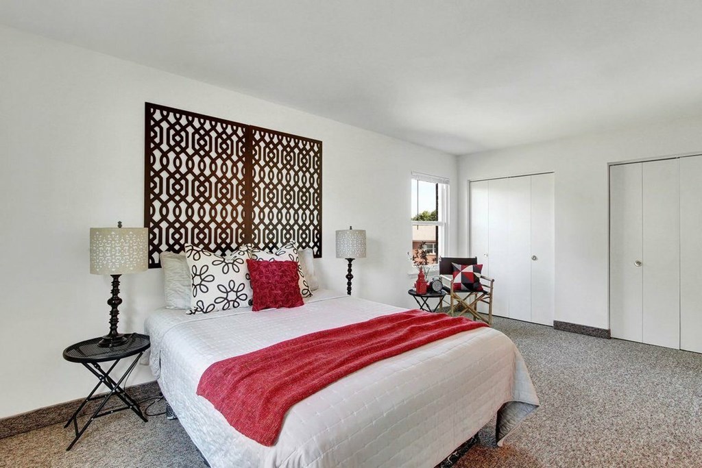 A bedroom with a large bed and a wooden headboard.