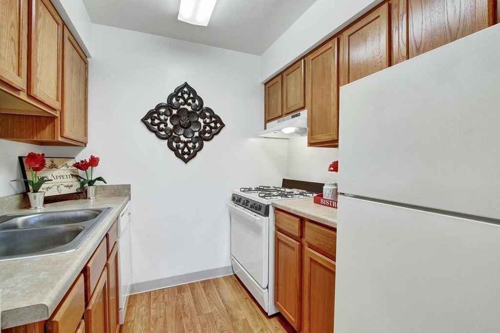 A kitchen with a white fridge and a white stove.