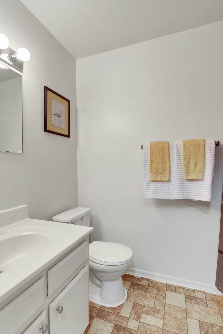 A white toilet sits next to a sink in a small bathroom.
