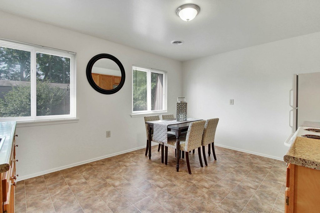A dining room with a table and chairs.